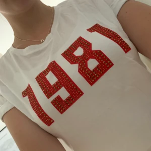 Guess t-shirt - Guess T-shirt aldrig använd då röd inte är min färg. Jätteskön i materialet och fin passform. Rött tryck med guld/bruna diamanter. Bjuder på frakt.
