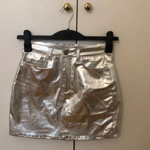 Silvrig kjol - Storlek 34. Frakt på 49kr tillkommer om den ska fraktas.PS har ej möjlighet att skicka fler bilder Pga mitt i en flytt!  