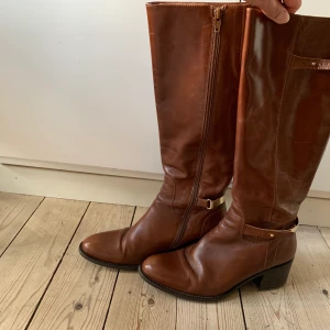 Bruna skinnstövlar - Novita storlek 38 - Sparsamt använda, fint skick men kan behöva putsas till där metallspännet sitter. 