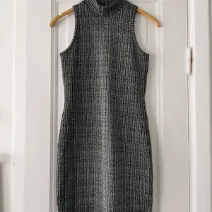 Snygg figurnära gråmelerad klänning med lätt polokrage. 