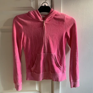 Kofta Juicy Couture  - Rosa kofta från Juicy Couture med tryck på ryggen. Storlek XS, jag är 163 cm och den sitter tight, men på ett snyggt sätt. Köpt för 1295kr säljes för 500 men priset kan diskuteras