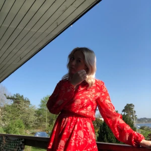 Klänning stl M  - Superfin röd ”blommig” klänning. I framsidan är det knappar och en liten krage vilket ger en fin modell. Frakt till kommer men priset går att diskutera 