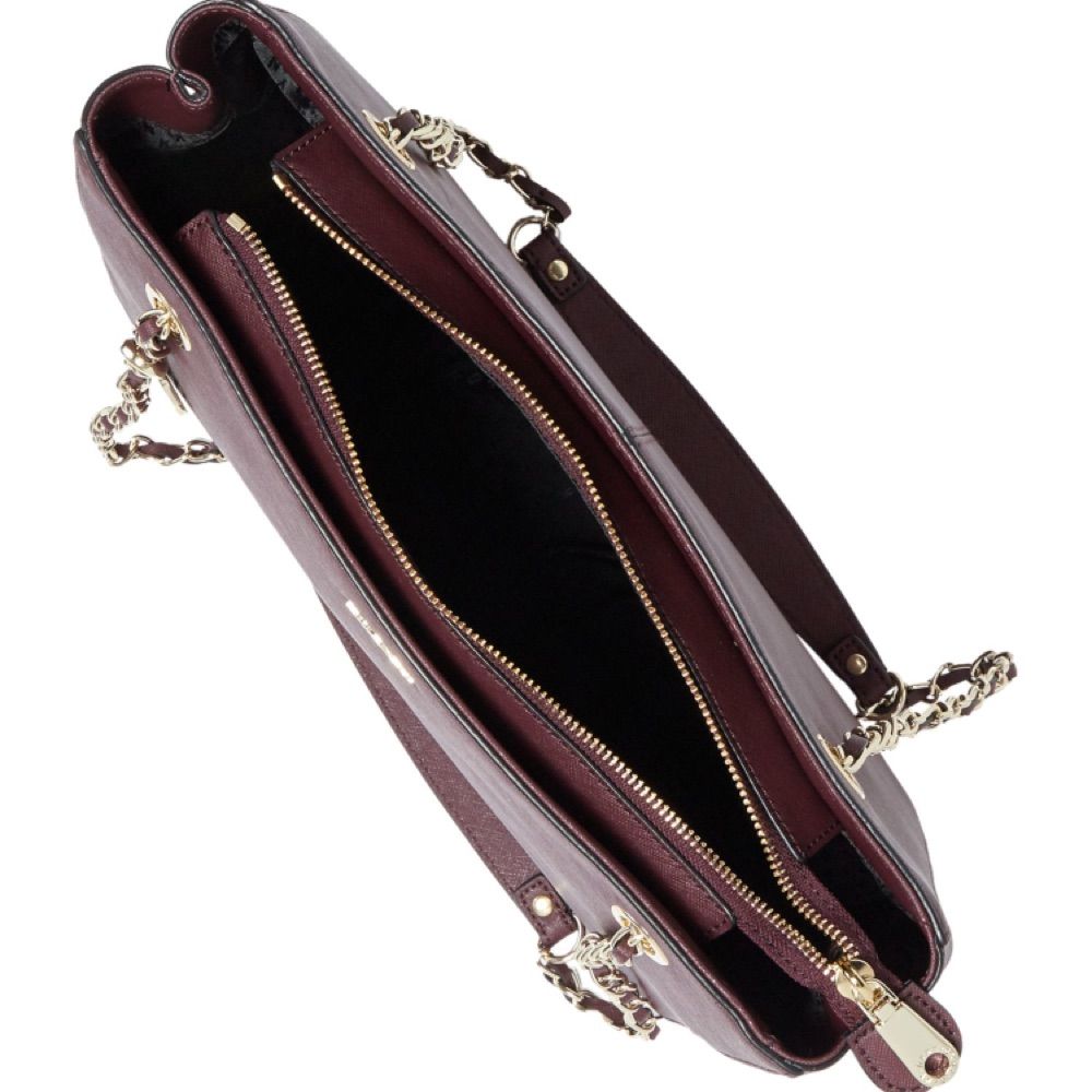 Äkta DKNY Purple Saffiano Burgundy Medium Tote Bag. Jättesvår färg att fånga på bild men den är mörklila, på sista bilden ser den nästan svart ut pga ljuset, men ville bara visa att den är i bra skick! Använd fåtal gånger, inga revor eller märken på väskan! Flera fack inuti och DKNY mönstrat foder. Gulddetaljer på kedjan och hänget vilket knappt syns men skickar jättegärna fler bilder vid förfrågan! Säljer pga inte riktigt min stil längre, nypris €236 men är villig att diskutera pris! Köpare står för eventuell frakt . Väskor.