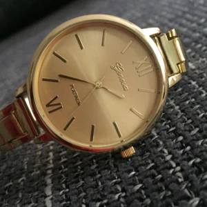  - Damklocka Geneva Platinum. Guldfärgad. Helt ny och aldrig använd. Batteri inkl. Skyddsfolie finns kvar på. Man kan justera längden på armbandsur. 