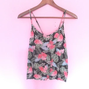  - Topp, oanvänd. Axelbanden går i kryss över ryggen. Sitter löst på kroppen. 