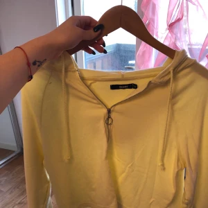 Tröja - Jag säljer en ljus gul tröja från bikbok. Det finns två små fläckar som man kan se på bilden. Det finns även luvan. Den är även lite tunnare, så man kan inte kalla de för tjocktröja.