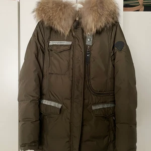 Hollies Vinterjacka dam - En jättesnygg och varm vinterjacka från Hollies med äkta pälskrage. Storlek 40 men passar om man är S/M och 36/38. Den har snygga detaljer! Använd ett fåtal gånger, väldigt bra skick. Nypris: 4300 kr Buda privat!