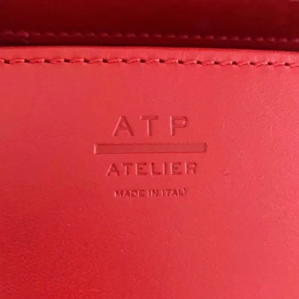 En röd ATP atelier Montalcino väska. Väskan är varsamt använd och är därför i mycket bra skick som visas på bilden. Pris kan diskuteras . Väskor.