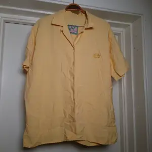 Kortärmad vintageskjorta i fin gul färg! Inte i nyskick men hel och fin. Ingen storleksmärkning men bedömmer den som en L🌼