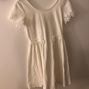 Vit klänning från La Redoute - En vit klänning från La Redoute i storlek 32/34 vilket motsvarat ca XS. Den har blommigt spetsmönster på ärmarna och runt midjan. Knappt använd. 