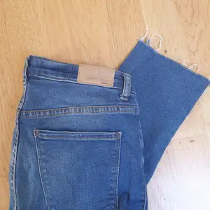 Mellablå jeans från Gina Tricot i modellen Emma. Färdiga slitningar längst ner på benet. Storlek 36 men skulle säga att de passar 34 om man vill ha de lite mer 