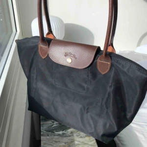 Väska - Fin svart longchamp väska. Ej äkta.  Ca 40 cm lång och 25 cm hög från botten till toppen.