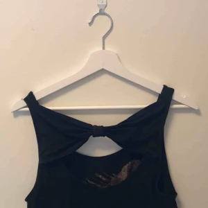  - Svart linne med rosettdetalj i ryggen och papegojatryck på framsidan!! 