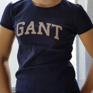 Gant t-shirt - Snygg tröja från Gant, använd ganska mycket men inte så sliten förutom att den rosa färgen på texten har blivit ljusare i tvätten. Tröjan är i storleken 146-152 men passar om man har storleken XS - S. Frakt tillkommer 💕😊