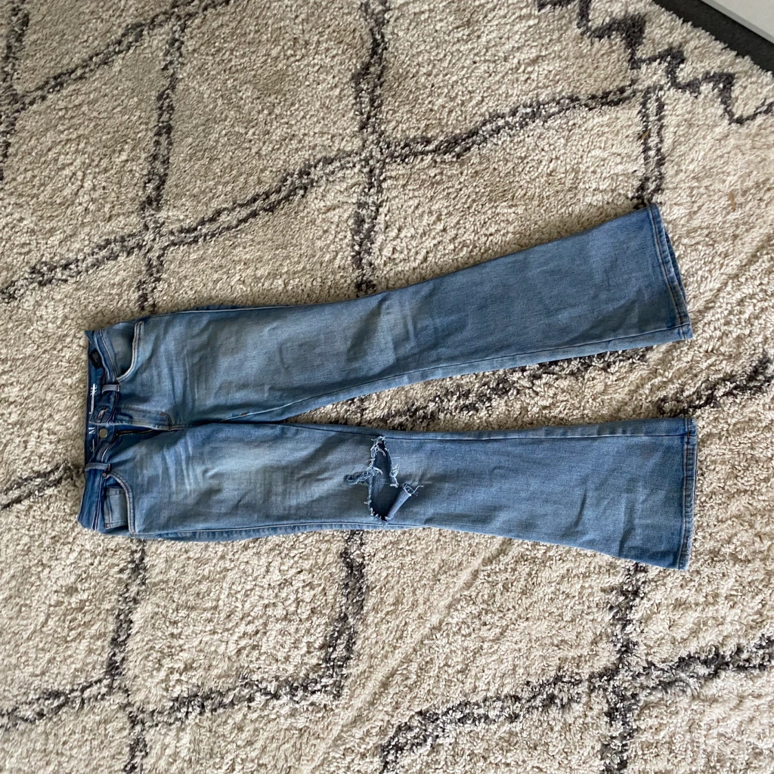 Bootcut med hål på ena knät