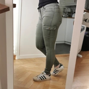 Tighta cargobyxor 36 - Snygga gröna byxor med fickor på låren! Lågmidjade! Sitter som en smäck på mig men kanske lite små i storleken för en 36. Kan mötas upp i centrala gbg. Hör av er om ni har frågor! [FRAKT INKLUDERAT I PRISET]