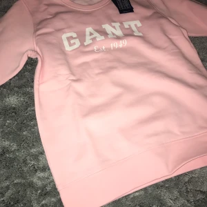 Gant sweatshirt  - Två rosa gant sweatshirt, ena med guld tryck och andra med vitt tryck. Den med guld tryck är i storlek S och den med vitt tryck är i storlek 170 cm (15 år). Helt oanvända och jag säljer för 400 kr styck.