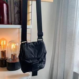 Weekday väska. - Perfekta väskan som rymmer allt en behöver. Sportigt material med två fack som stängs med dragkedja.