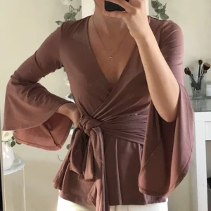 Tröja från Bubbleroom - Långärmad tröja från Bubbleroom, endast använd ett fåtal gånger. Vida ärmar och knytning i midjan, färgen är som på sista bilden. Fraktkostnad tillkommer om du ej vill hämta på plats, kan även mötas i Lund.