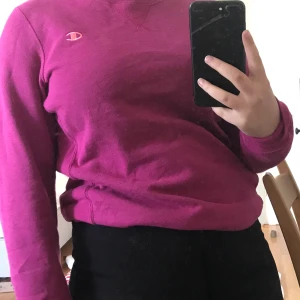 Champion tröja - En skitsnygg rosa sweatshirt/collagetröja från Champion. Tröjan är köpt på Beyond Retro men har bara använt den 2 gånger. Den är i strl L men skulle rekommendera om man brukar ha S/M.