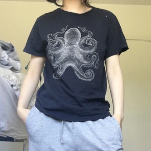 T-shirt med bläckfisk tryck - En tunn marinblå T-shirt från H&M med ett fint bläckfisk tryck, den lilla vita fläcken på axeln var bara lite damm som jag tog bort efter men orkade inte ta om bilderna. Frakt 22 kr