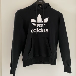 Adidas klassisk hoodie - Klassisk adidas hoodie i svart, strl 38 men något liten i storleken. Använd, men inga fläckar eller slitningar! Köpt för 700, säljs för 200kr exkl frakt (kan eventuellt mötas upp i sthlm)