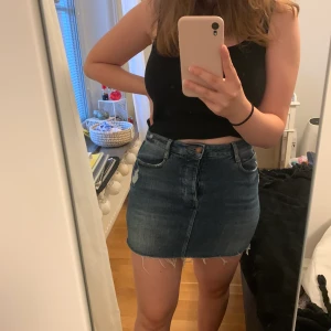 Zara jeanskjol strl S - Kort jeanskjol från Zara med slitningar. Säljer eftersom den är för liten. Är lite mer blå än vad det ser ut som på bilderna.