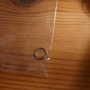 En ring-piercing som är silverfärgat. Upptäckte att den var i fel storlek så aldrig använd. 1,2*10mm. Köparen står för frakten