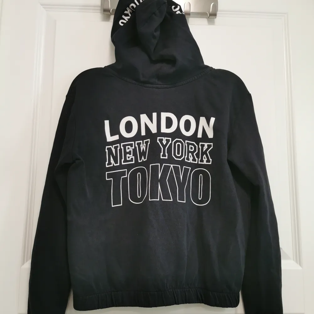 Svart luvtröja med vitt tryck från H&M i storlek 146/152. Hoodies.