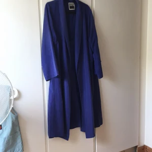 Kappa från Weekday - En snygg kornblå kappa från Weekday, köpt här på Plick. Den går ner till anklarna på mig som är 156cm. Ett litet hål i innerfickan, går att sy ihop. Finns katter i hemmet.
