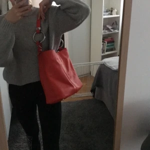 Brandröd väska från zara fakeskinn - En brandröd väska från zara där dator får plats. Har en innerficka. Det är fakeskinn och den är som ny i kvaliten. 