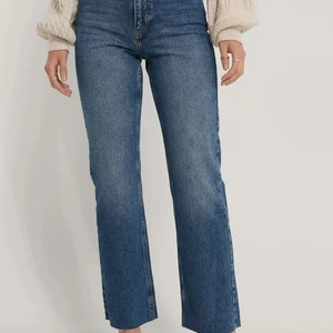 Straight jeans Nakd strl 34 - Säljer dessa jeans i färgen mid blue från nakd. Aldrig använda (prislappen sitter kvar). Modellen heter Organic Straight High Waist Raw Hem Jeans i storlek 34. Köparen står för frakten.