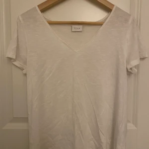 T-shirt  - Vit T-shirt från Vila. Är i storlek M men skulle säga att den passar en S också 👍🏼 tröjan är väldigt genomskinlig, så perfekt att bara ha hemma eller bara dra över en bikini i sommar. Pris kan diskuteras. Köparen står för frakten 🥰 frakten är spårbar