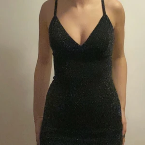 Svart glittrig klänning strl XS - Svart figursydd glittrig klänning till cirka knäna på mig 157 cm. Går att ändra längd på bysten. Aldrig använd  Köpare står för frakt. 
