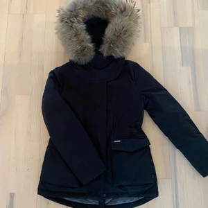 Woolrich jacka - Svart vinterjacka från Woolrich med pälskrage. Knappt använd och i mycket fint skick! Stor härlig luva med stora fickor.