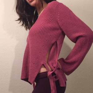 Pink sweater with cute details on the side.