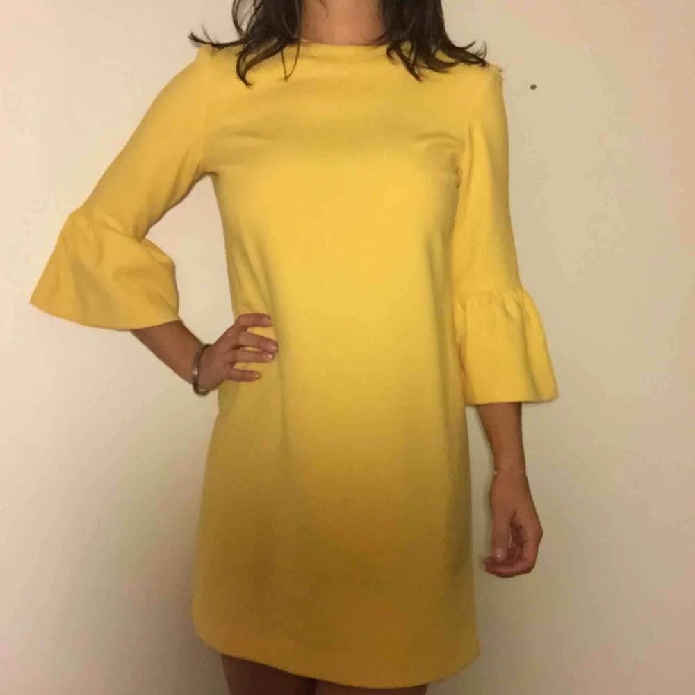 Härlig gul klänning med volangärmar! I storlek S från Zara. Den har några små, knappt synbara, fläckar som framgår av sista bilden. . Klänningar.