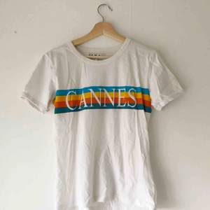 Vit t-shirt med trycket ”Cannes” över bröstet. 100% ekologisk bomull. I nyskick, använd en gång. Köparen står för frakt eller möts upp i Uppsala 💫