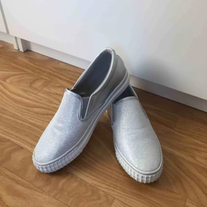 Silvriga slip on sneakers - Dessa slip-on skor är köpta utomlands förra året.  Kommer inte ihåg vad ordinarie pris var men super fräscha och enbart testade. Skulle säga att de passar någon i storlek 39 EU och 38  Märke: TOPLAY