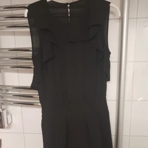  - Svart byxdress med volang övertill. Fint skick!! Frakt tillkommer 💕