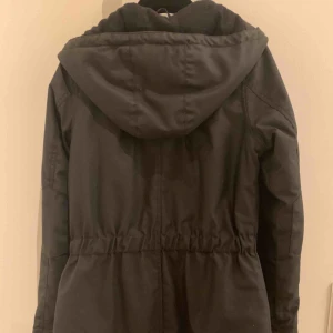  - Elvine-jacka svart med gulddetaljer i storlek XS. Mycket fint skick. Knappt använd. Fint foder invändigt o mjukt svart fleece i luvan och inuti. 