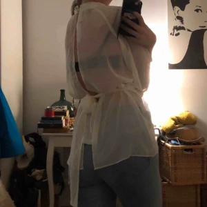  - Tunn blus med öppen ryggg och knappar vis halsen. Ett band som gör till ger formen i midjan men kan uteslutas. Helt ny, lappen sitter kvar. Köparen står för frakt:)