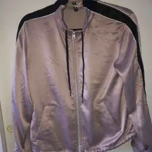 En pastell lila jacka från H&M. Har snören borde i halsen och längst ner. Har dragkedja.  Frakt ingår inte