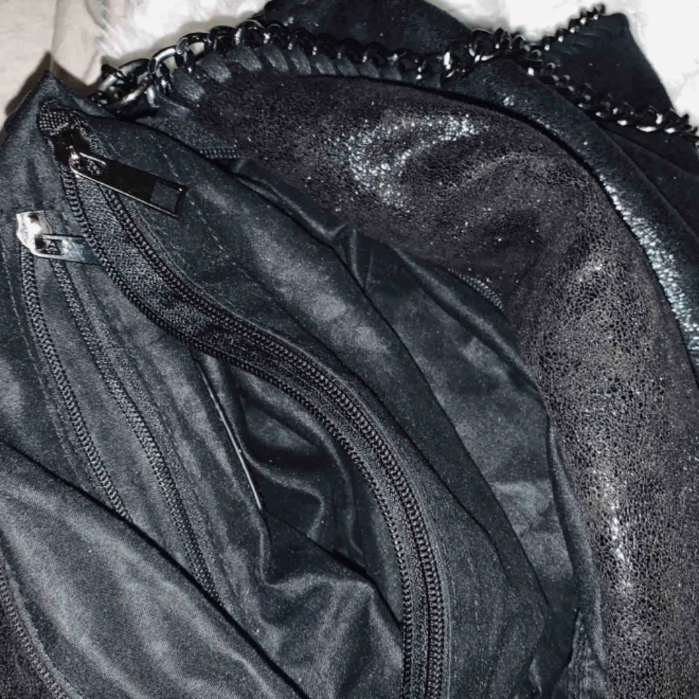Stor svart väska med två mindre fickor/fack med dragkedja samt ett större ”fack”. Säljer för 60kr. Kan mötas upp i Göteborg eller posta (+frakt). Delvis defekt med ett hål i innersta fickan, men det är lätt ihopsytt!♠️ utöver det är väskan i bra skick. Väskor.
