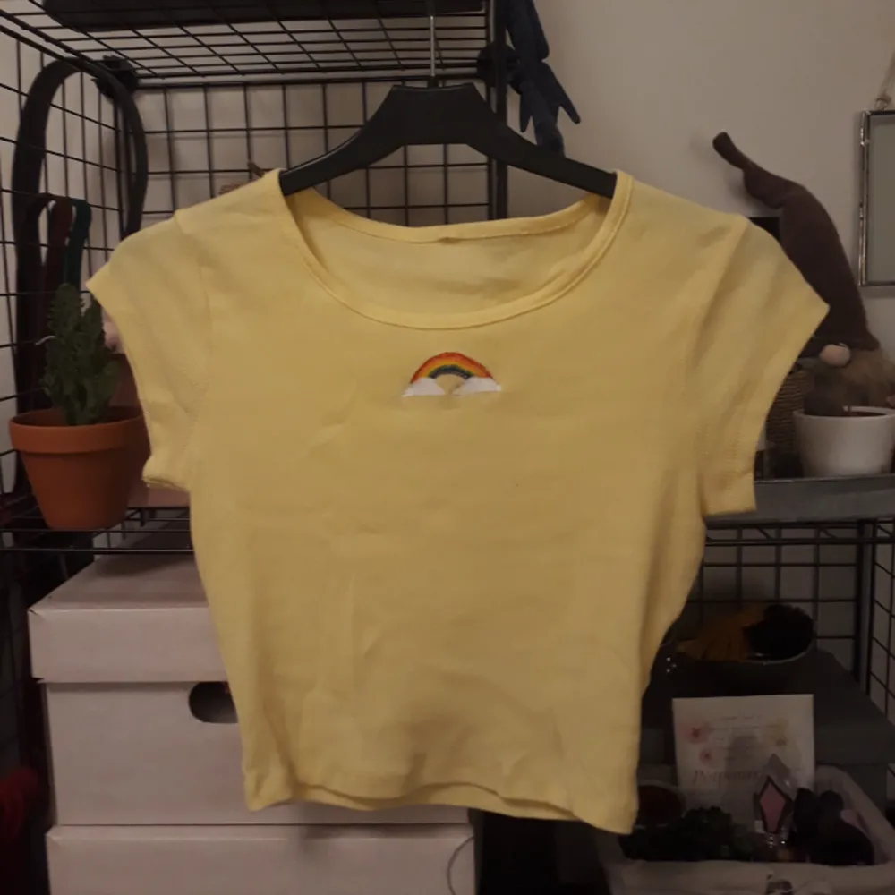 Ljus gul t-shirt med korta ärmar och en målad regnbåge. Den är lite genomskinlig därav priset. Fråga om du har nån eller  vill ha mer bilder😋🌈  Tvättas i 40°C. T-shirts.