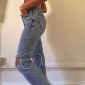 Levis straight leg jeans - Säljer mina jättefina Levis jeans med hål på knäna. Köpte dessa second hand förra året. Jag är 171 cm och de räcker nästan ner till hälen på mig. HÖGSTA BUD 500kr. Budningen slutar ikväll kl 23