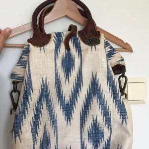 Canvasväska Ralph Lauren - snygg weekend väska i canvas från Ralph Lauren. Snygga läderdetaljer och knäppning. Finns även en axelrem. Väskan har måtten 40x40 cm. Frakt tillkommer