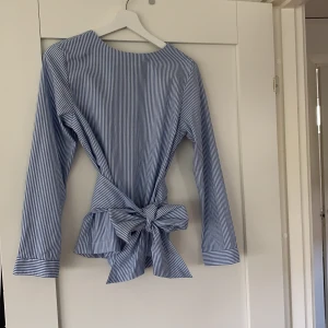 Gant blus - En härlig sommar blus med ett band som knyts i midjan, randig blus med en härlig färg💗 blusen är ifrån gant med storlek 34. Har knappt användt denna blusen skulle klassa den som splitter ny💗