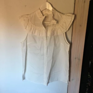  - Superfin kortärmad blus med volangkrage och ärm. Tyvärr aldrig kommit till användning så den är som ny!