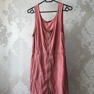  - Jerseyklänning med dragkedja och resår. Cirka 90cm från axel. Den har fickor i sidan också. Nyskick